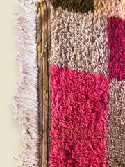 Tassadit rug corner with pink, green  blocks and white fringe