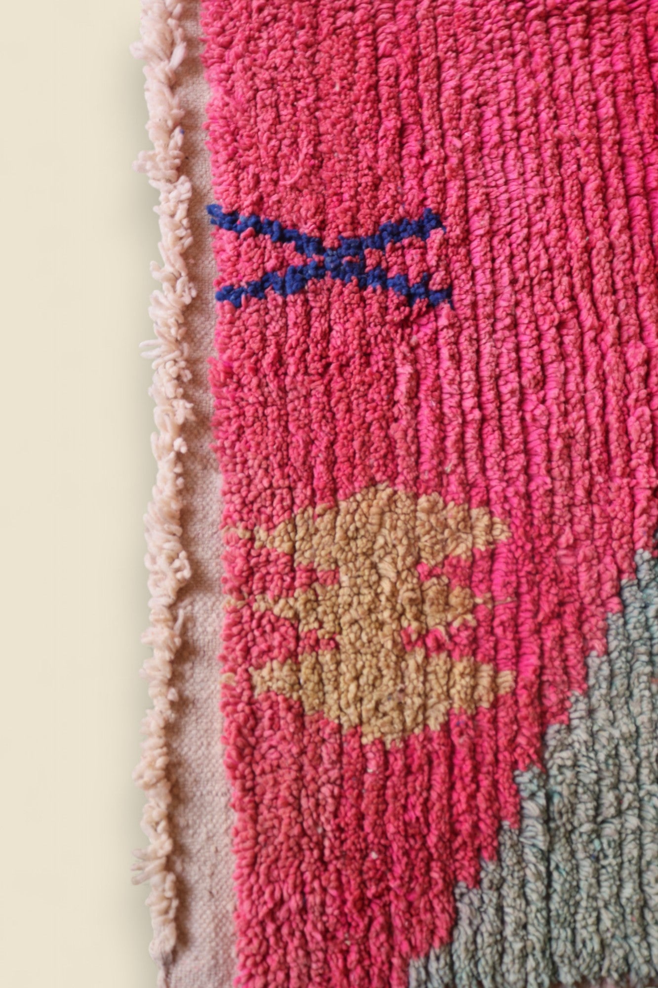 Bottom corner of the rug with tribal yellow motif and soft green section