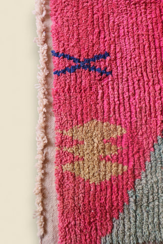Bottom corner of the rug with tribal yellow motif and soft green section