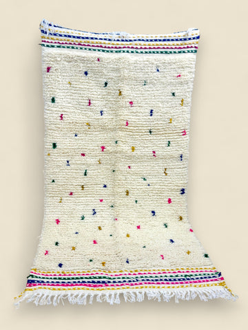 Ivory Berber rug with rainbow stripes and hand-knotted fringe.