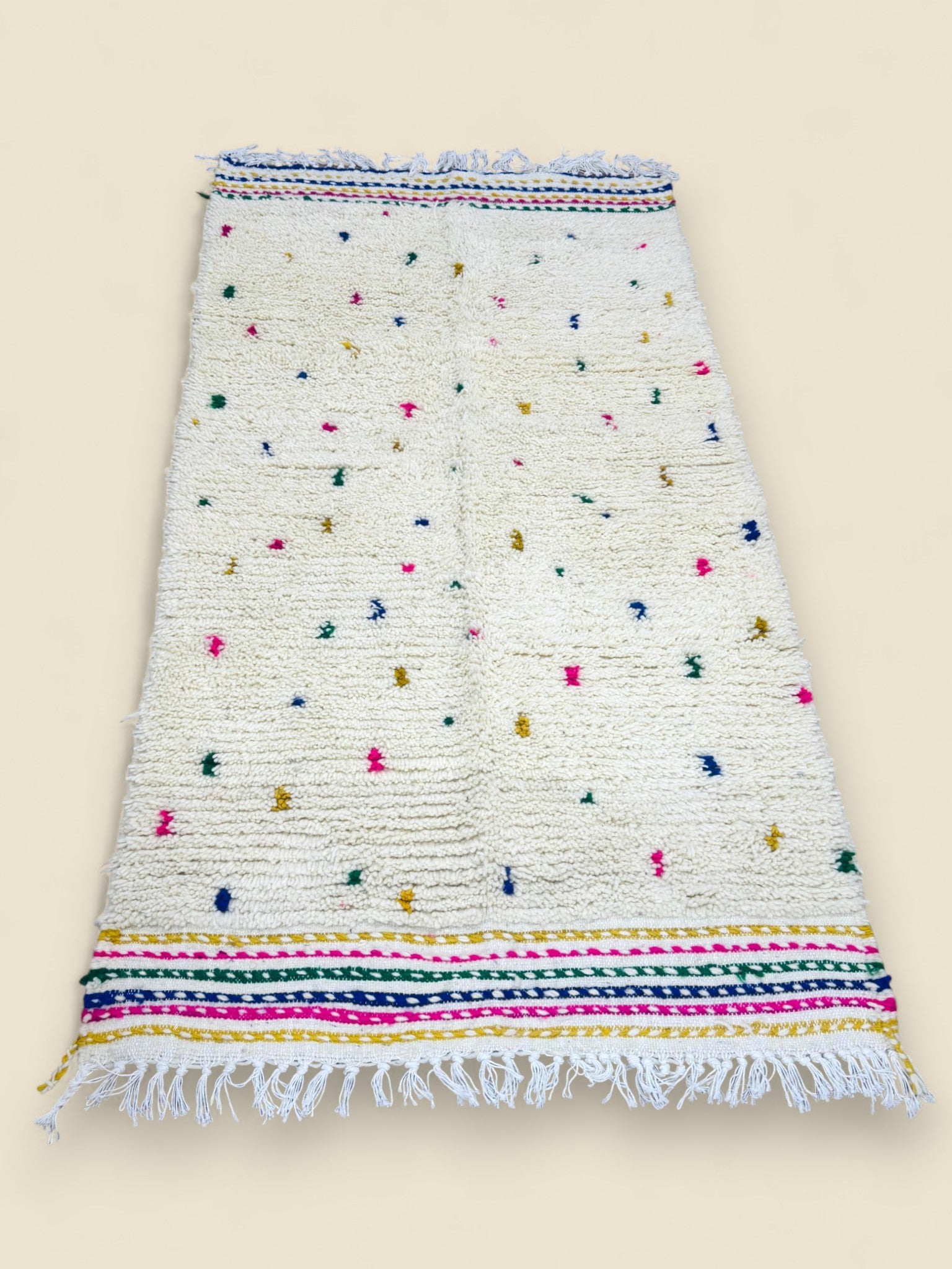 Handmade Berber rug in ivory with multicolor accents and striped borders.