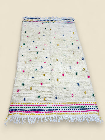 Handmade Berber rug in ivory with multicolor accents and striped borders.