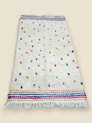 Handmade Berber rug in ivory with multicolor accents and striped borders.