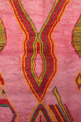 Central diamond pattern of the Limra rug in red, mustard, and olive green