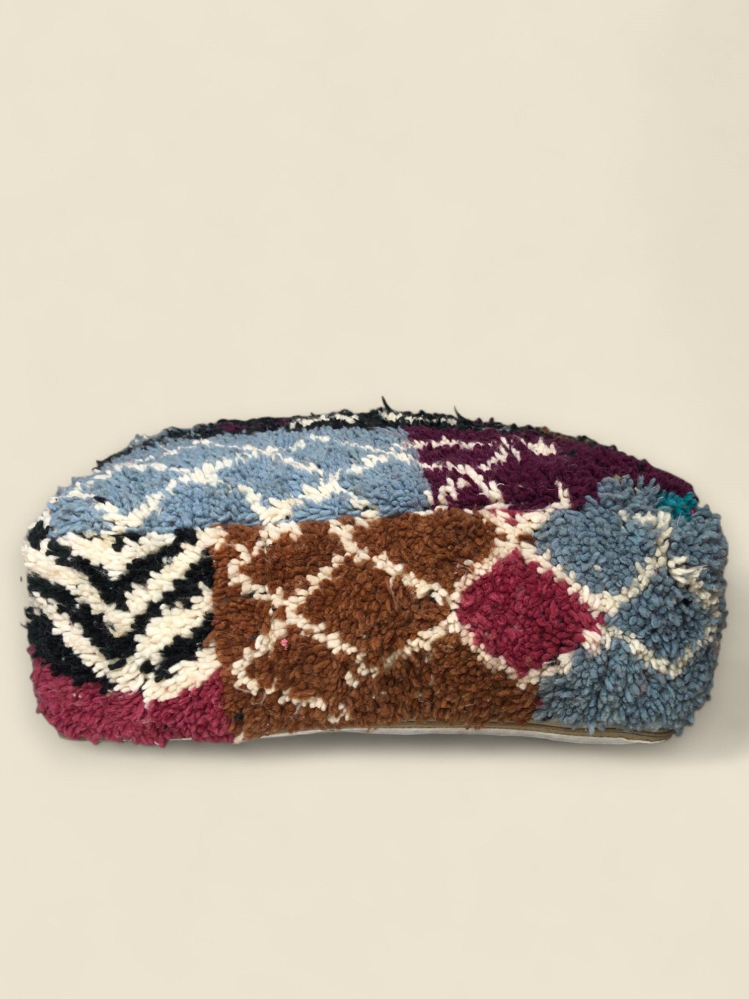 Side view of pouffe with burgundy shag and bold Berber motifs