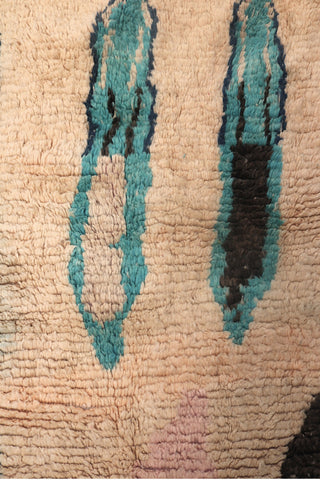 Top section detail of the Hafna rug featuring elongated teal and black forms.