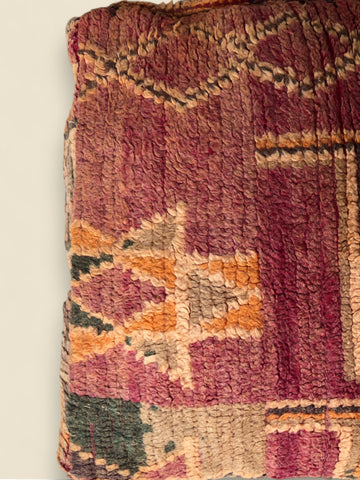 Left side detail of the Tizwit pouffe in warm vintage tones