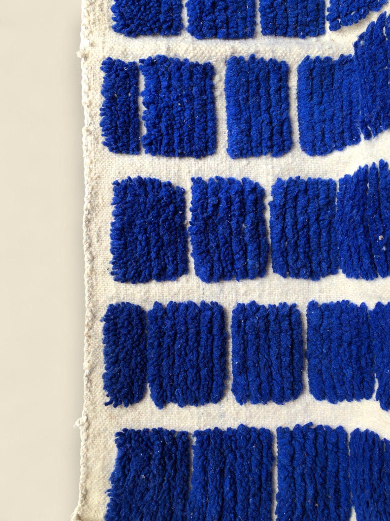 Close-up of blue textured blocks on the Tanit wool rug