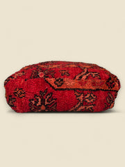 Side view of vintage Moroccan wool pouffe in deep red tones