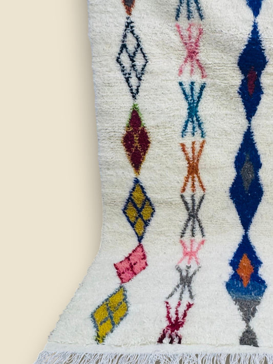 Handmade Massinissa Berber rug with colorful diamond patterns on white wool