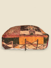Vintage Moroccan pouffe with traditional Berber motifs and warm natural hues
