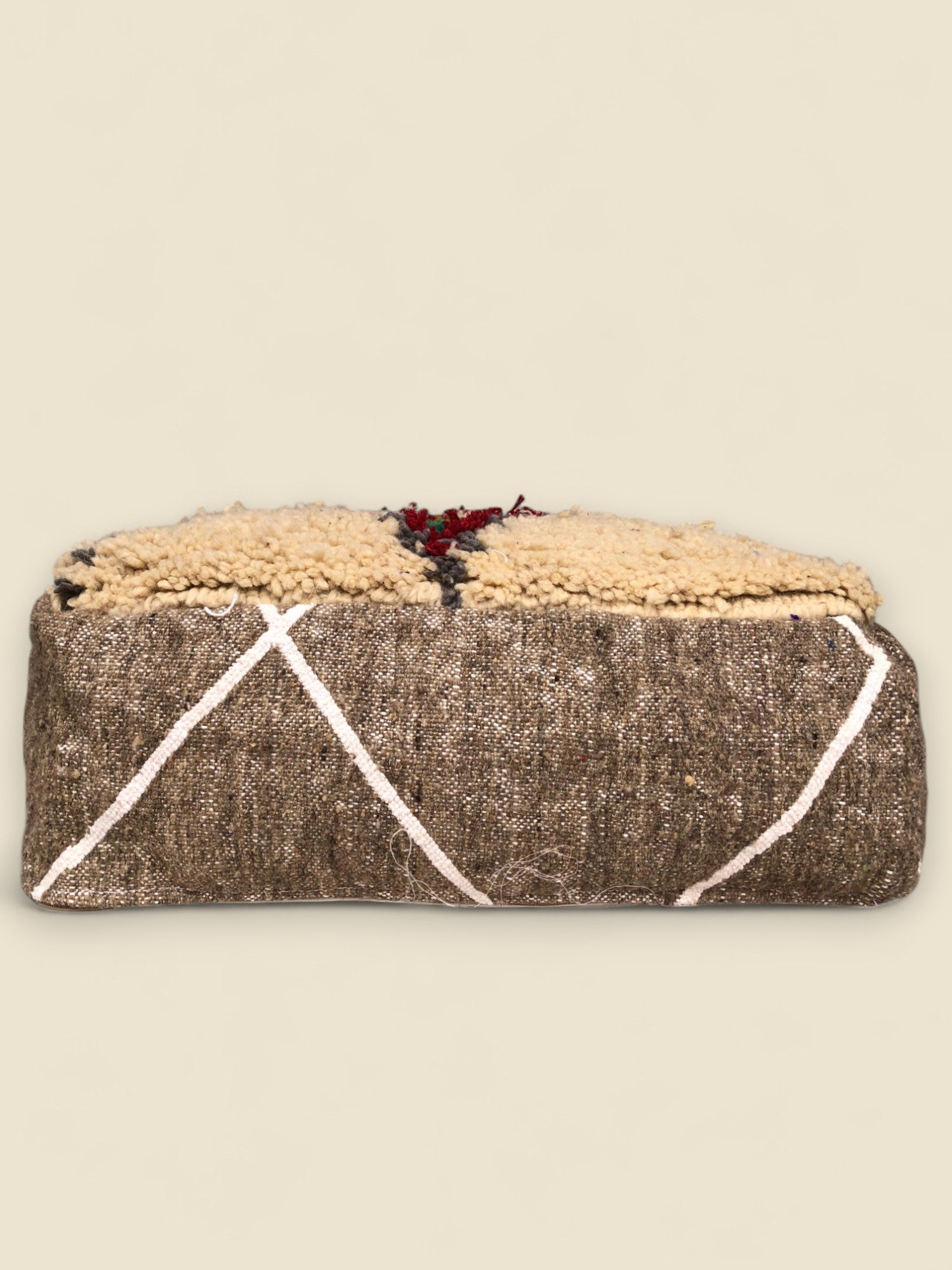 Side view of Moroccan pouffe with brown woven base and white geometric lines