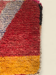 Detail of Tawenza pouffe top showing red and gold wool pattern