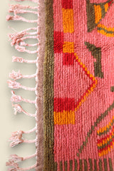 Handwoven edge and fringe of the Limra Berber rug in pink with red and mustard blocks