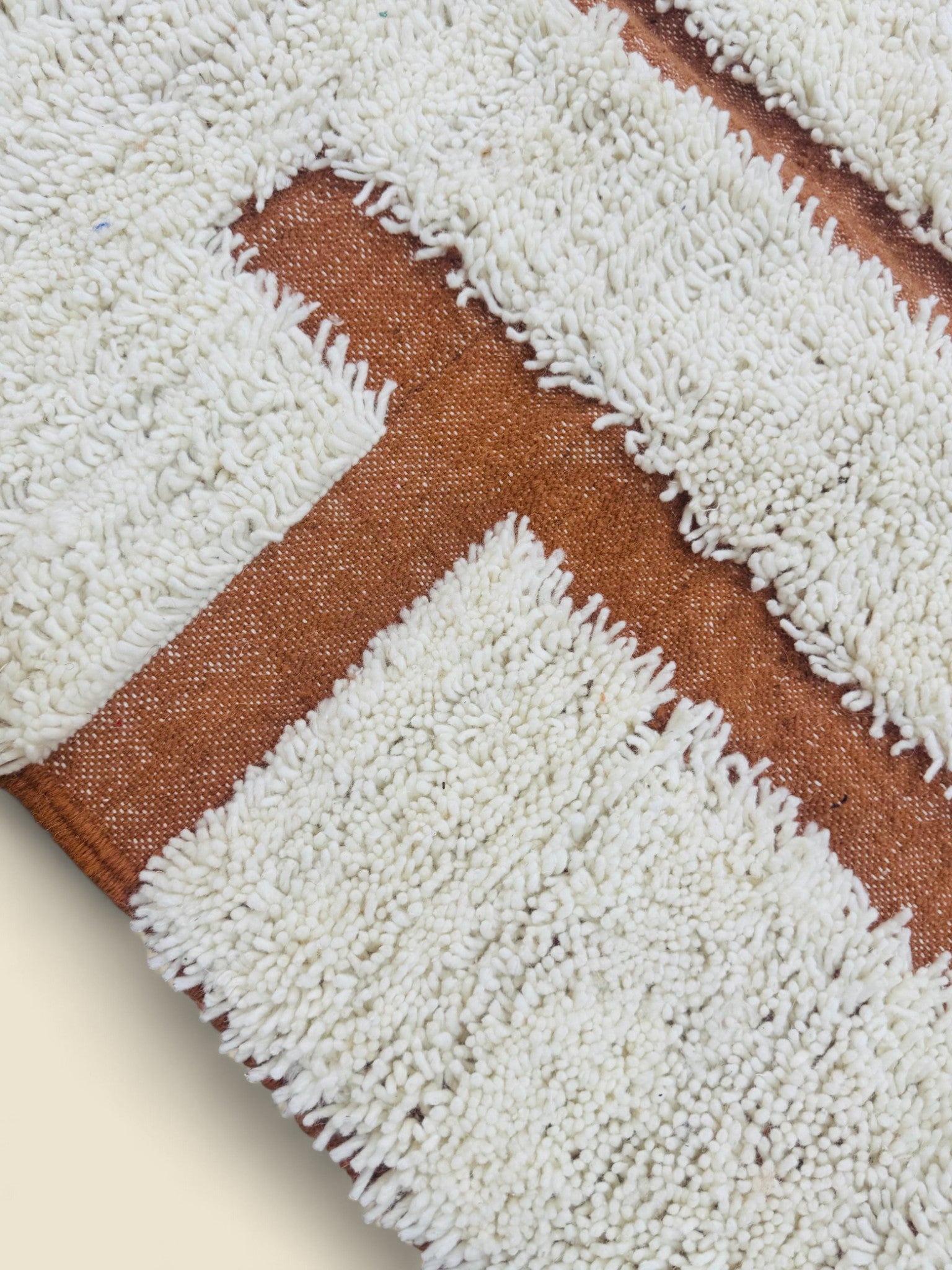 Close-up photo shows the wool of the berber rug 
