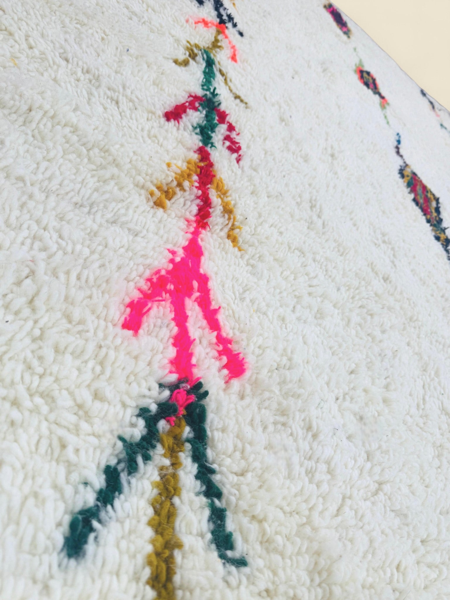 Detail of bright tribal patterns on cream Moroccan Berber rug