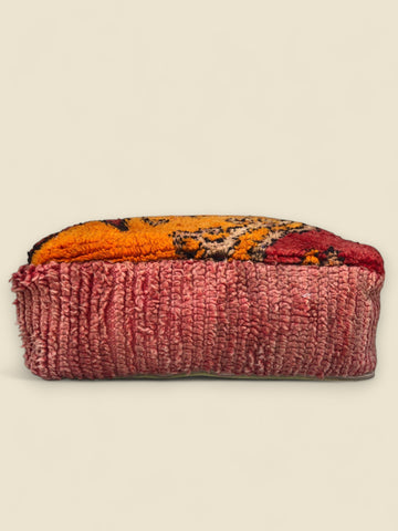 Side view of Tamghart Moroccan pouffe made from vintage red and orange Berber wool