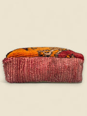 Side view of Tamghart Moroccan pouffe made from vintage red and orange Berber wool