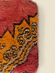 Close-up of the colorful geometric wool pattern on Tamghart pouffe