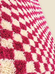 Detailed side view of pink and white wool checkerboard rug texture