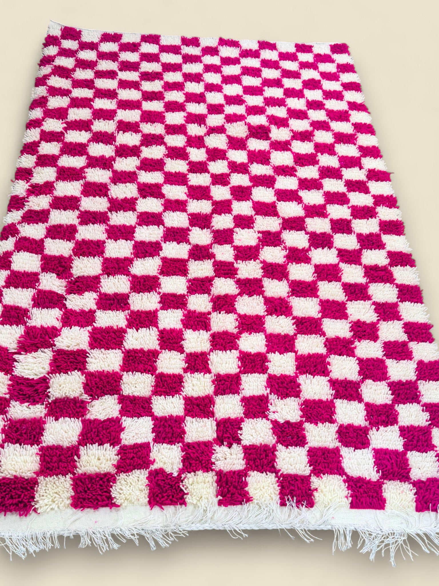Tamilla handmade Moroccan rug with pink and ivory checkerboard pattern on wooden floor