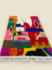 Colorful abstract Moroccan Tawenza Berber rug on wooden floor.
