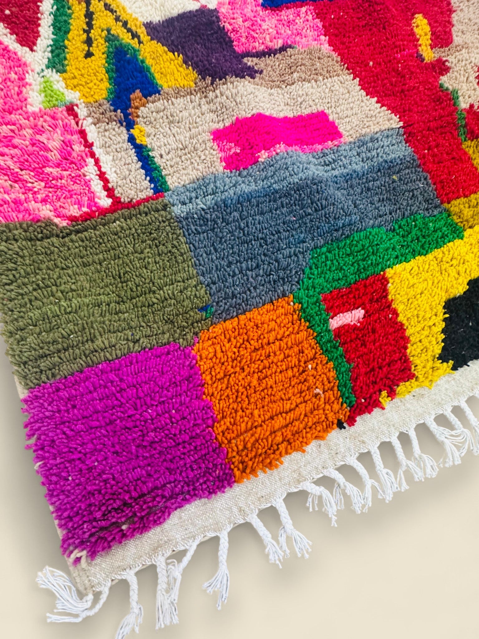 Corner view of Tawenza Berber rug with purple, orange, and green tones.