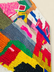Side angle of colorful Moroccan wool rug with abstract blocks.