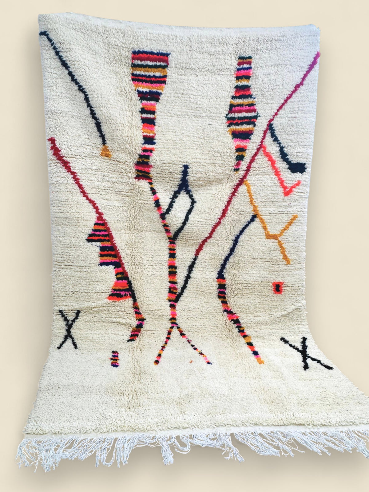 Full view of the Tazla rug showing multicolored lines and cream wool texture.