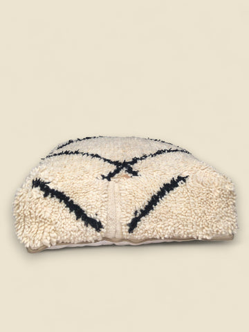 Textured clutch bag with geometric pattern on a beige background