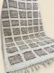 Side angle of Tilila rug showing checkered design and tassel fringes