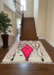 Moroccan colorful Berber rug placed in entryway near staircase