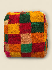 Top view of handmade Tirga Moroccan pouffe with bold multicolor checkerboard design