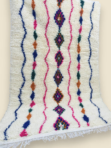Handwoven Moroccan Tiziriwen rug displayed vertically against wall