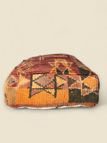 Handwoven Tizwit Moroccan pouffe with rust, Orange, and green Berber patterns