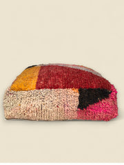 Side view of handwoven Tawenza pouffe with multicolor Berber wool textures