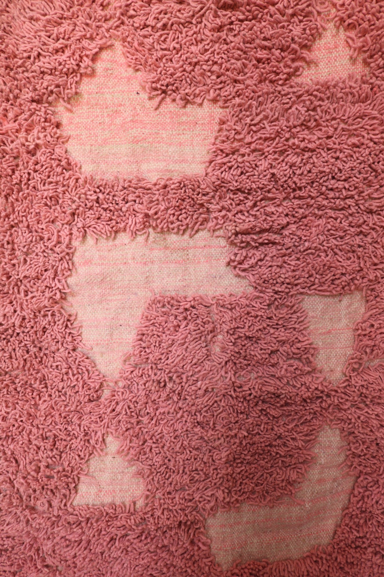 Central portion of the rug showing organic geometric cutouts in pink pile
