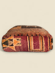Side view of the Thaziza pouffe showing vintage tribal patterns and bold stripes