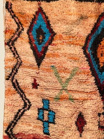 Close-up of a textured rug with geometric patterns in various colors.