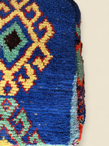 Close-up of a colorful knitted fabric with geometric pattern on a beige background