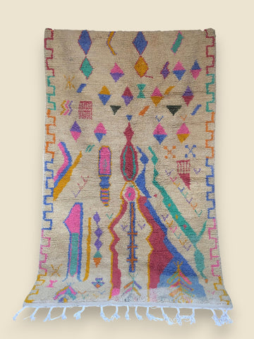 Colorful geometric patterned rug with tassels on a beige background