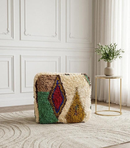 Moroccan wool pouf cube with geometric design, artisan-made for bohemian and eclectic interiors.