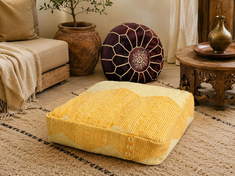 Artisan mustard Berber wool pouf displayed in a cozy Moroccan-inspired living room with traditional décor.