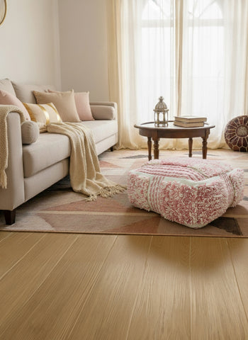Pink Berber pouf styled in a warm living room with neutral décor.
