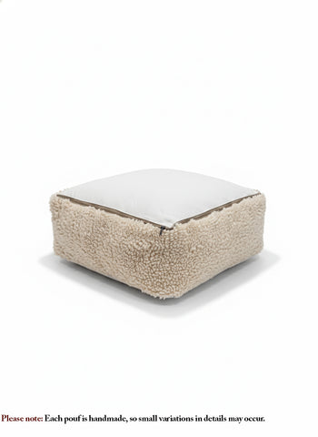 Handmade beige wool pouf with zipper underside, soft sherpa-style texture.