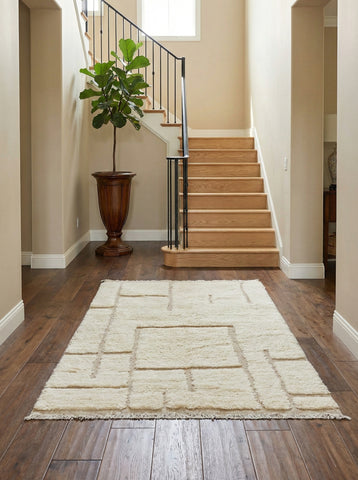 Handmade Berber Yuba wool rug placed in a modern entryway with wooden stairs.