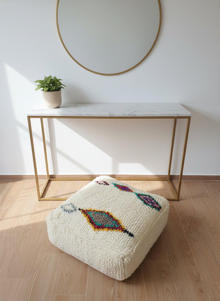 Handwoven Amnay pouf with colorful motifs in sunlight.