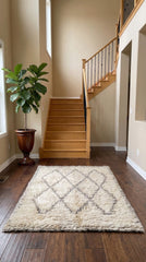 Moroccan Tifra rug in bright entryway near wooden stairs