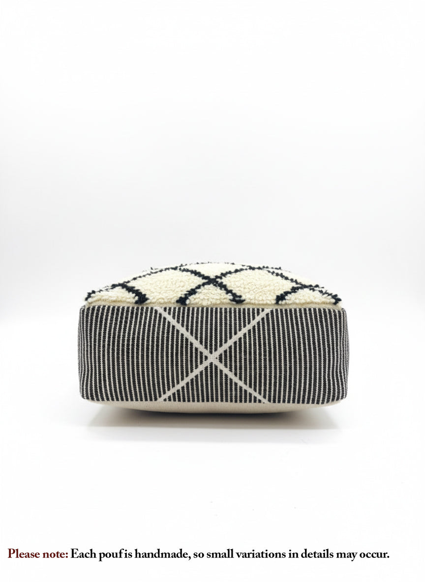 Front view of a handmade beige and black Berber pouf with geometric patterns.