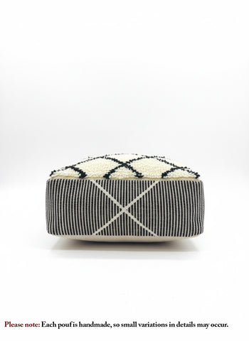 Front view of a handmade beige and black Berber pouf with geometric patterns.